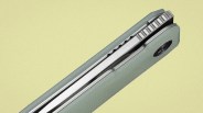 Close-up of a folded gray pocket knife with textured handle and visible metal blade spine.