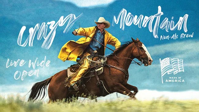 An ad campaign for Crazy Mountain beer showing a cowboy riding a horse wearing a yellow jacket against a bright blue sky