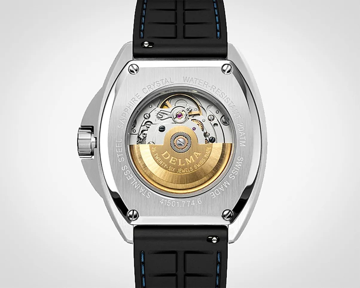 Back view of a Delma stainless steel watch with visible automatic movement and black strap with blue stitching.