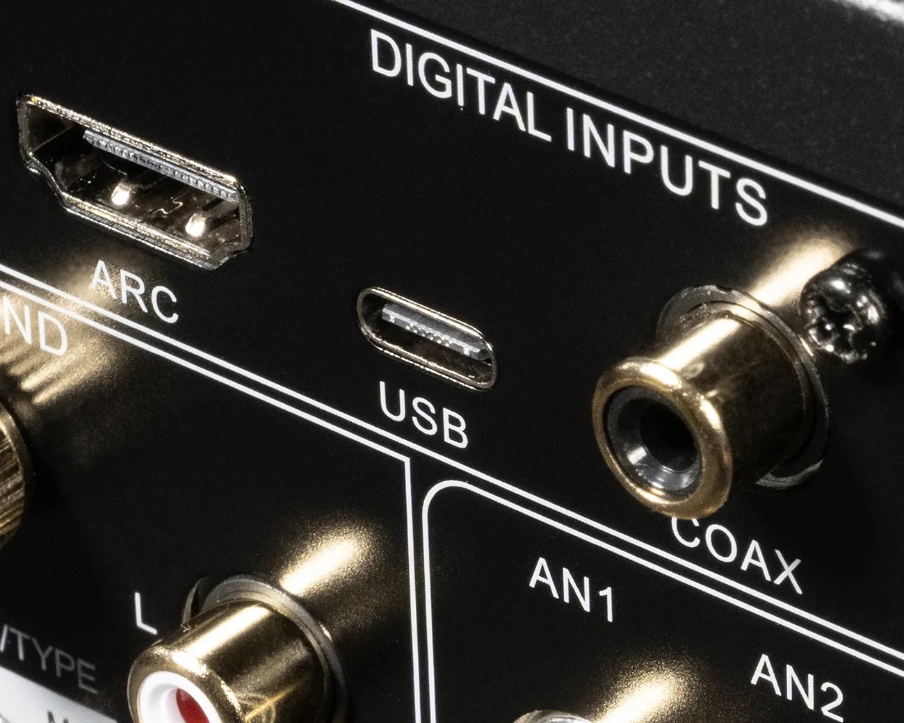 Close-up of digital input ports on a black electronic device, including HDMI ARC, USB-C, and coaxial connectors.