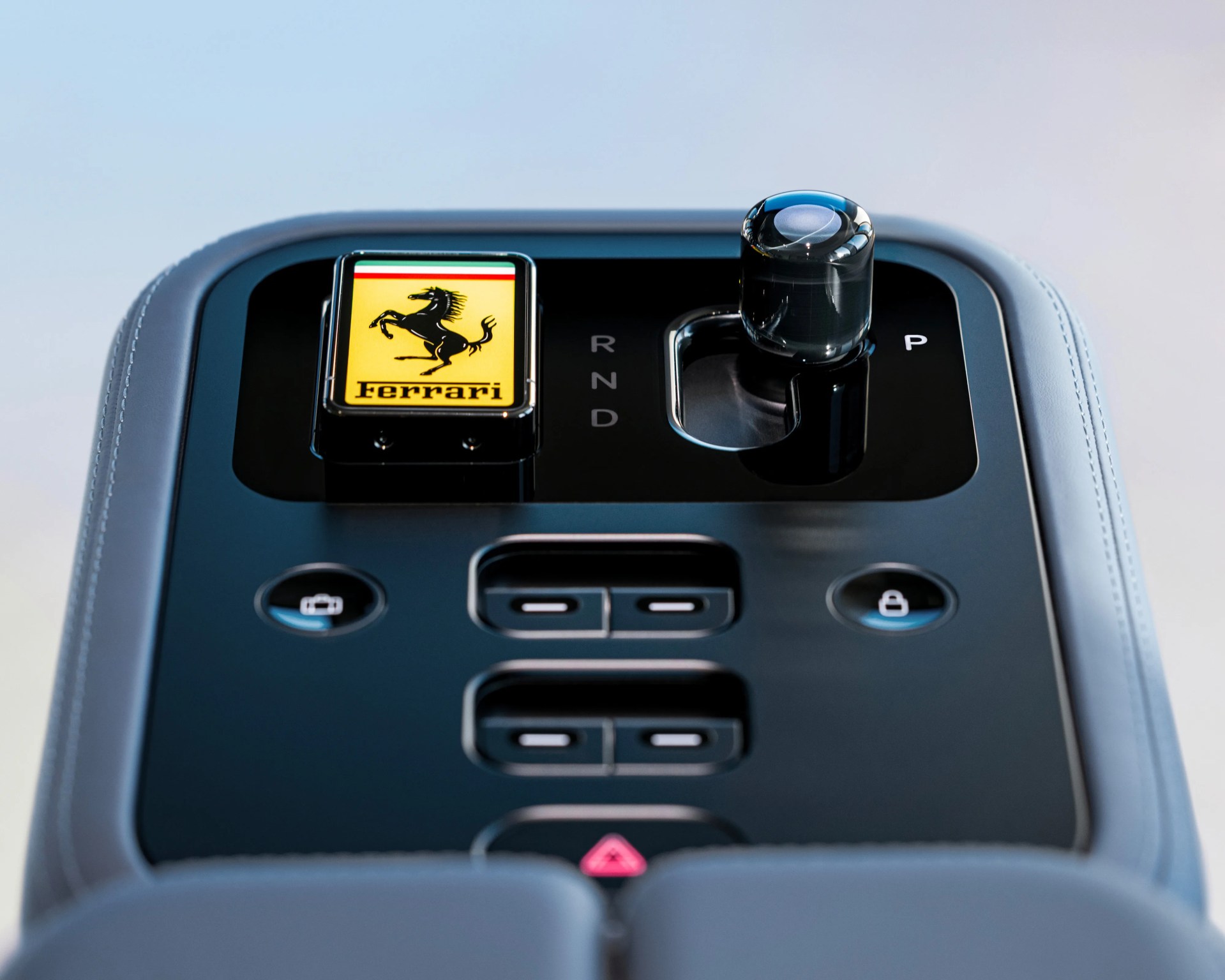 Black Ferrari gear selector panel with a crystal shift knob and a yellow Ferrari logo button.
