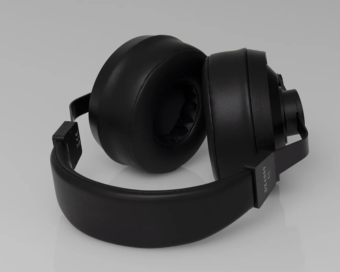 Black over-ear headphones with padded ear cups and headband on a gray surface.