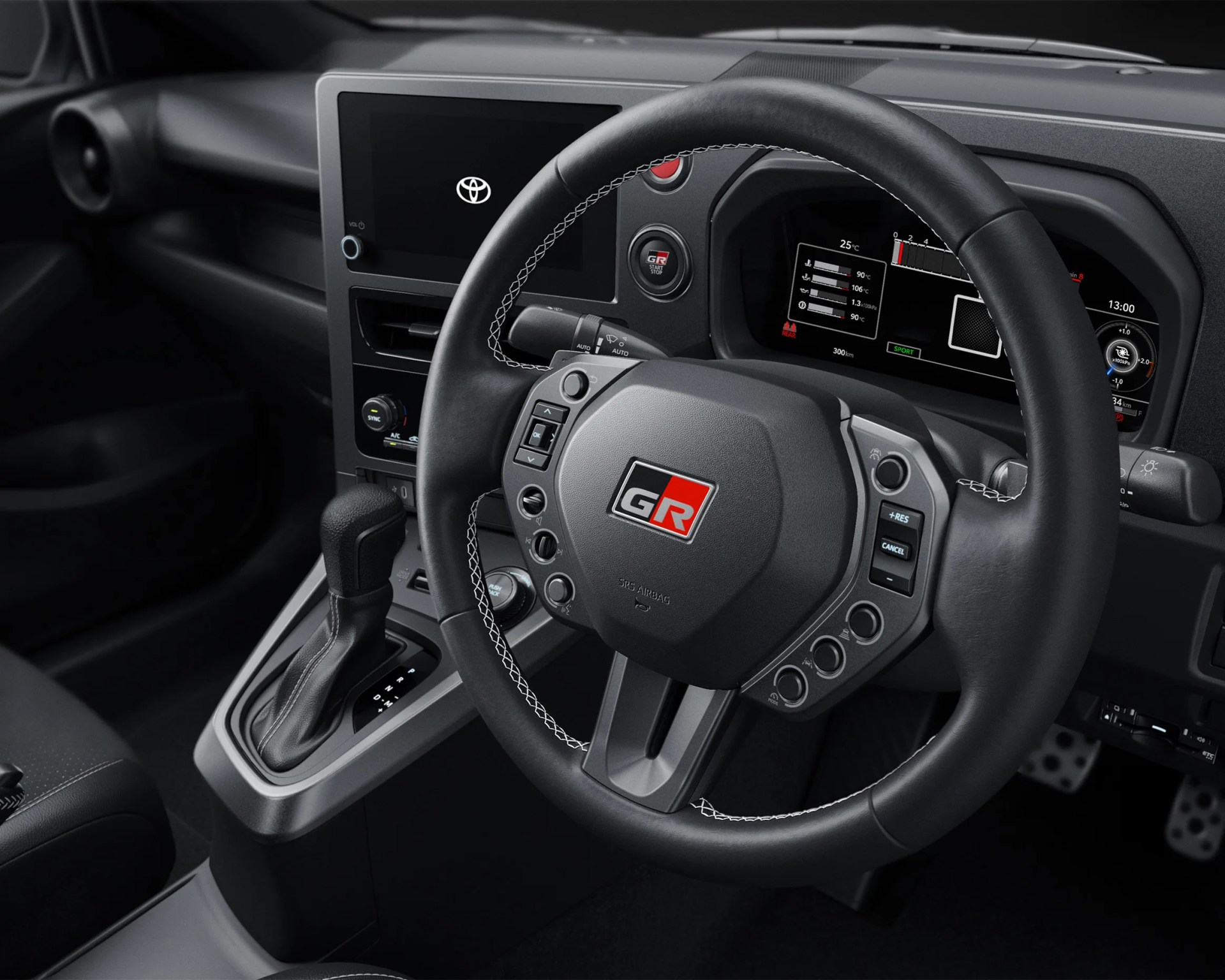 Black leather-wrapped Toyota GR steering wheel with white stitching and digital dashboard behind it.