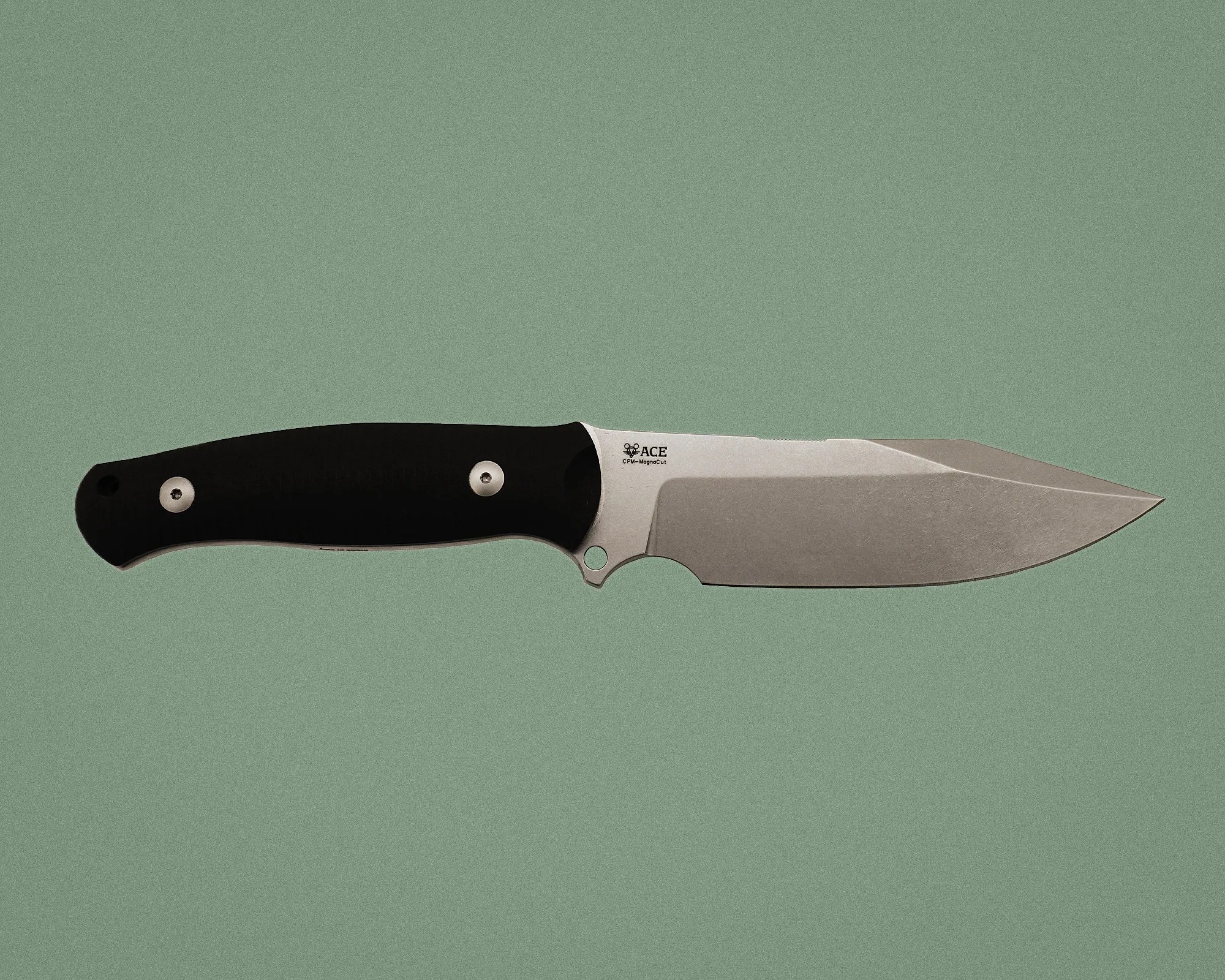 Fixed-blade knife with a stonewashed stainless steel blade and black ergonomic handle on a green background.