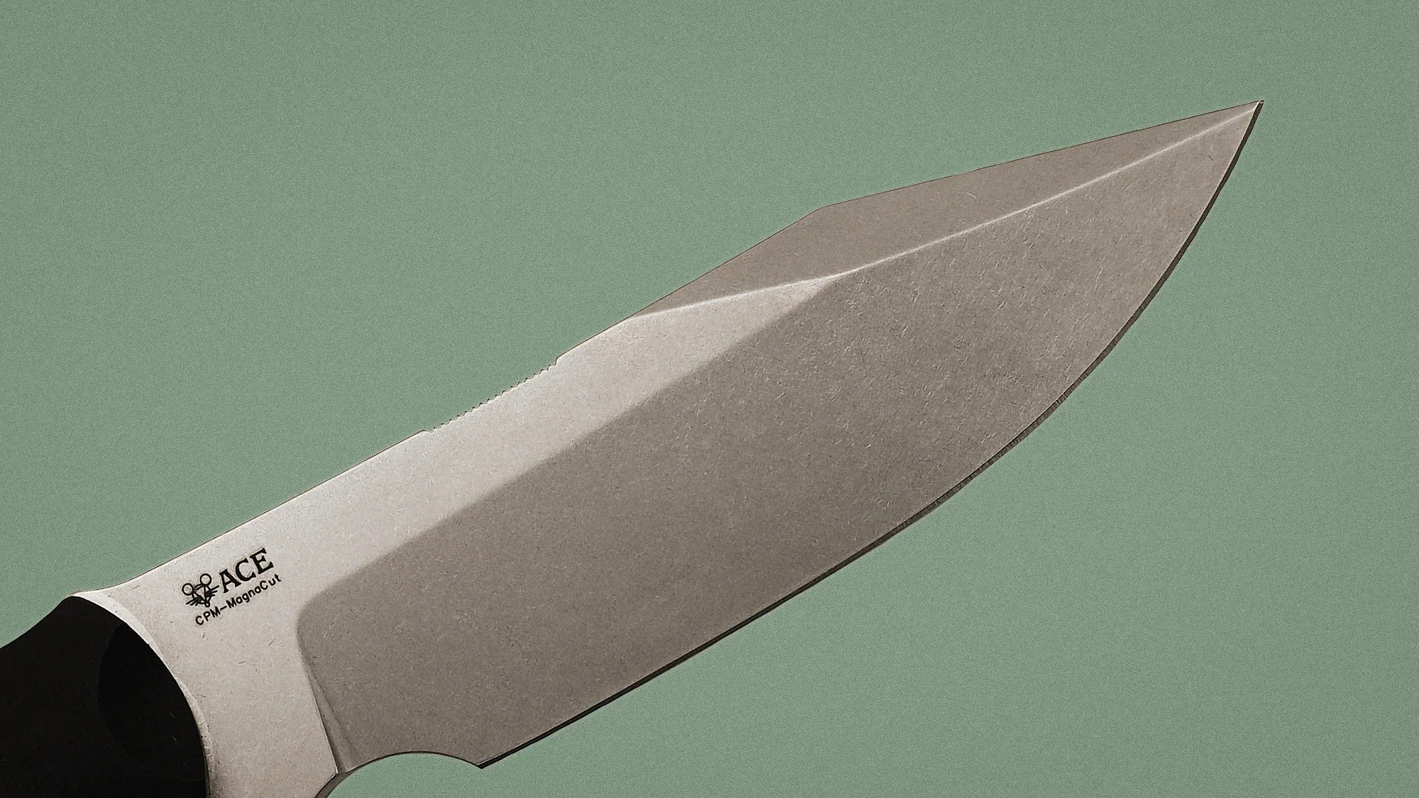 Close-up of a stainless steel knife blade with "ACE CPM-MagnaCut" logo on a green background.