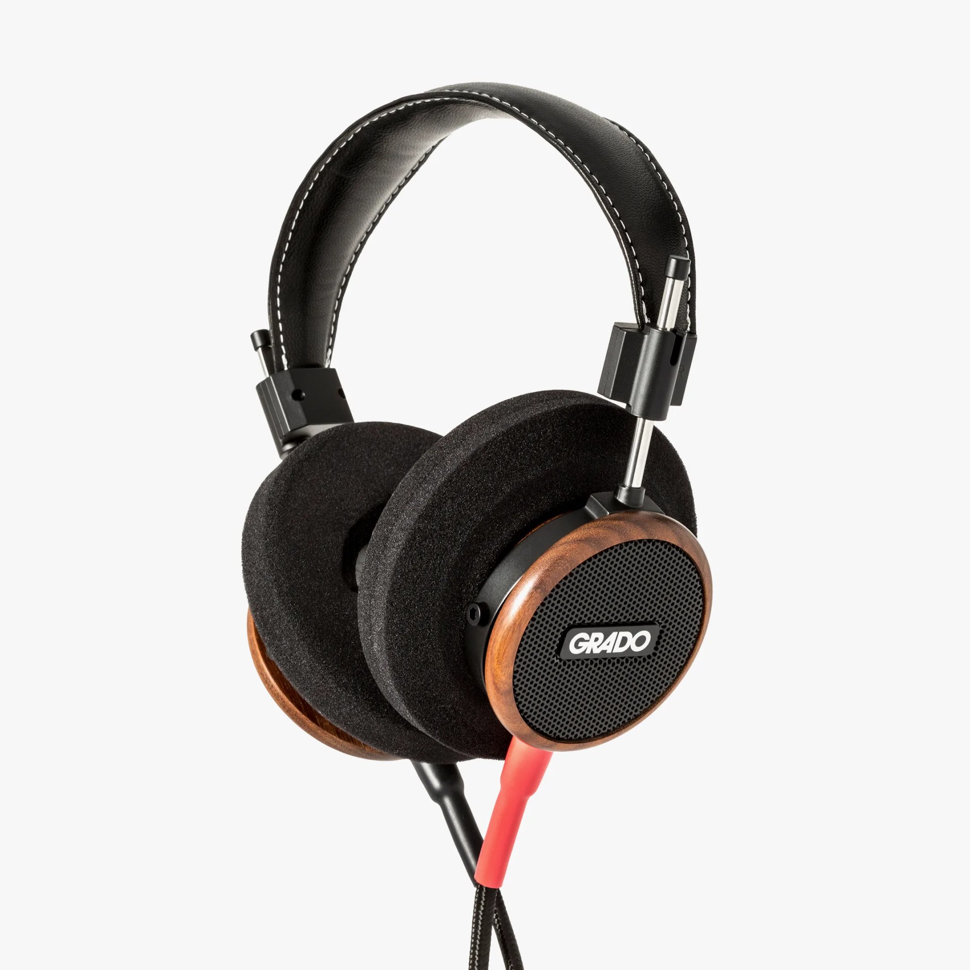 Over-ear Grado headphones with black foam ear pads, wooden ear cups, and black headband with white stitching.