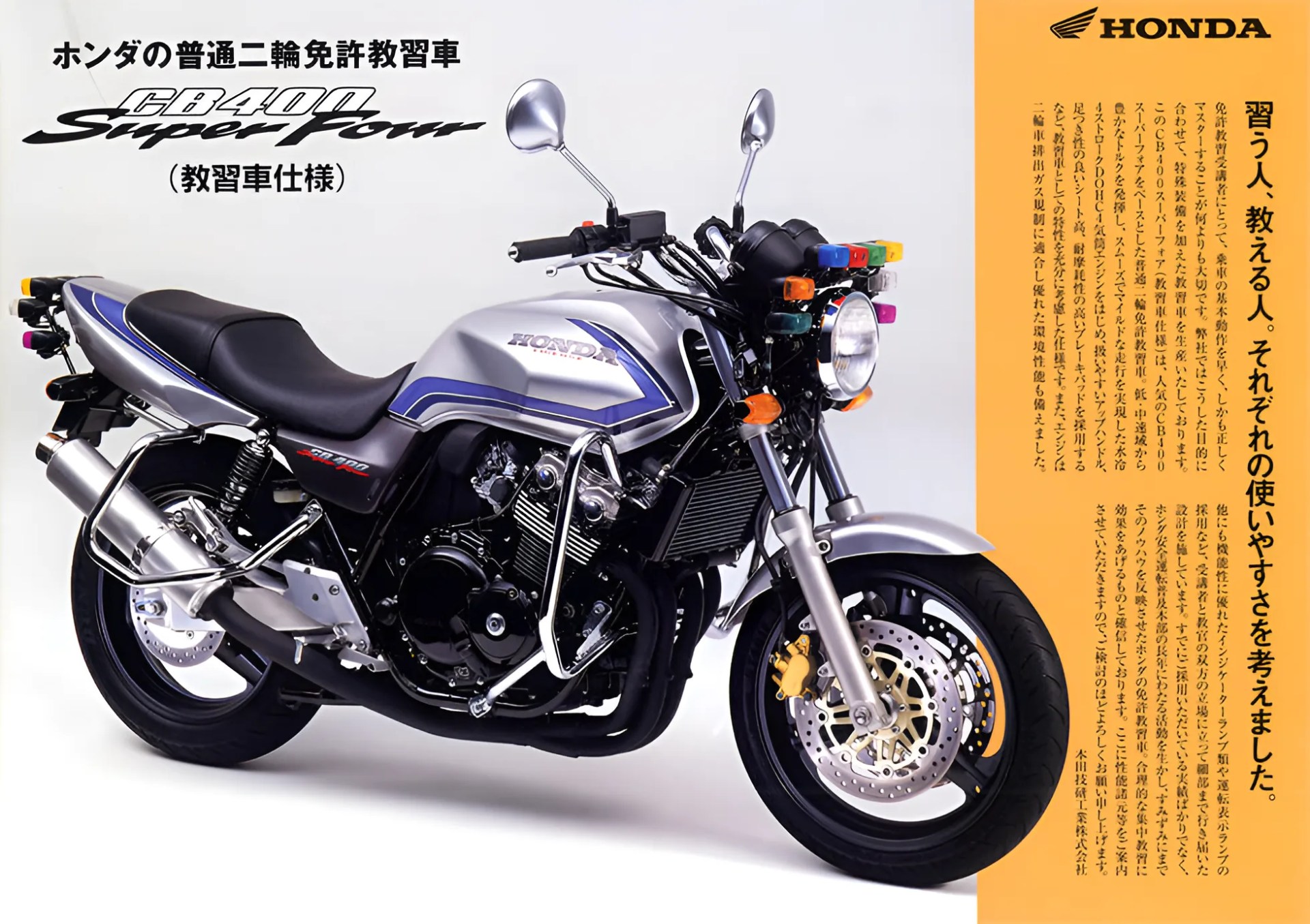 Silver and blue Honda CB400 Super Four motorcycle with black seat and multiple colored indicator lights on the front.