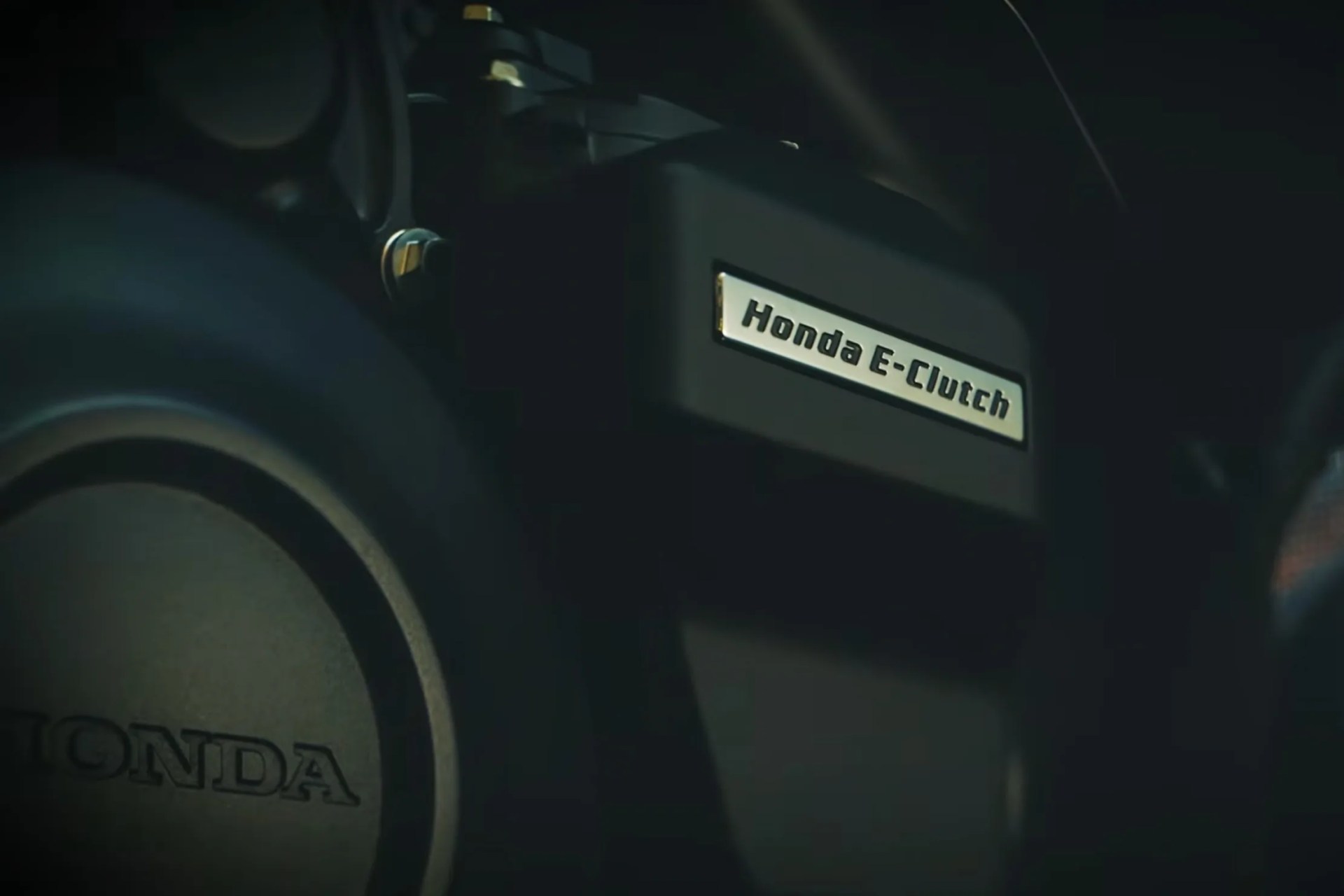 Close-up of a black Honda E-Clutch component with a Honda logo on a circular part nearby.