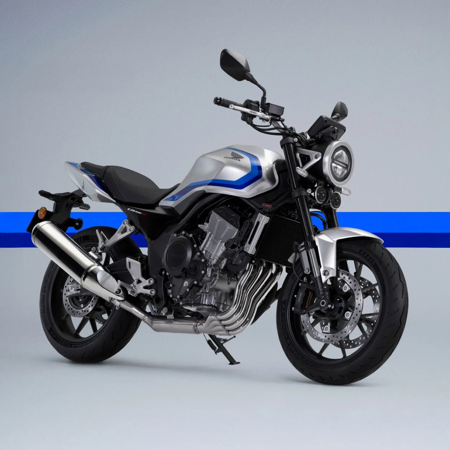 Silver and black Honda CB400 motorcycle with blue accents and round headlight on a gray background.