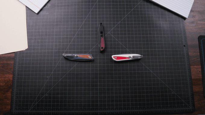 Three knafs knives spin around a gridded desktop pad