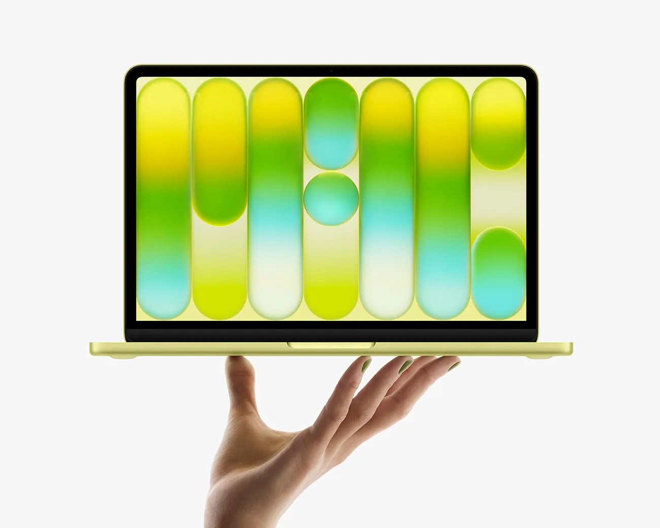 Light green laptop with colorful abstract wallpaper held on an open hand against a white background.