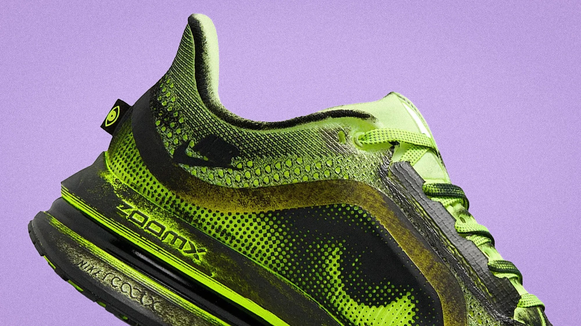 Green and black Nike ZoomX running shoe with a honeycomb pattern on a purple background.