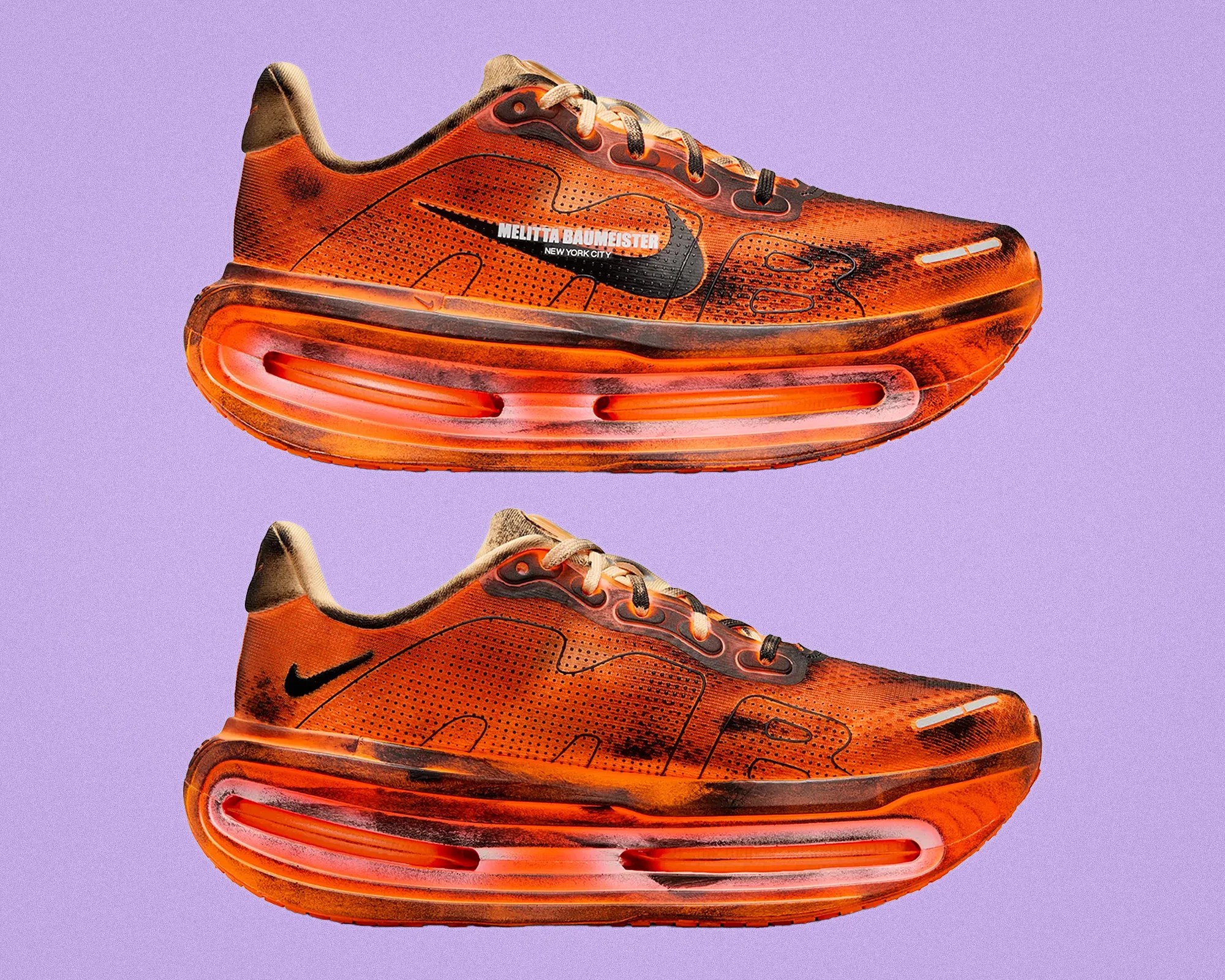 Pair of orange and black Nike Air Max sneakers with "Melitta Baumeister New York City" text on the side, shown from both sides on a purple background.
