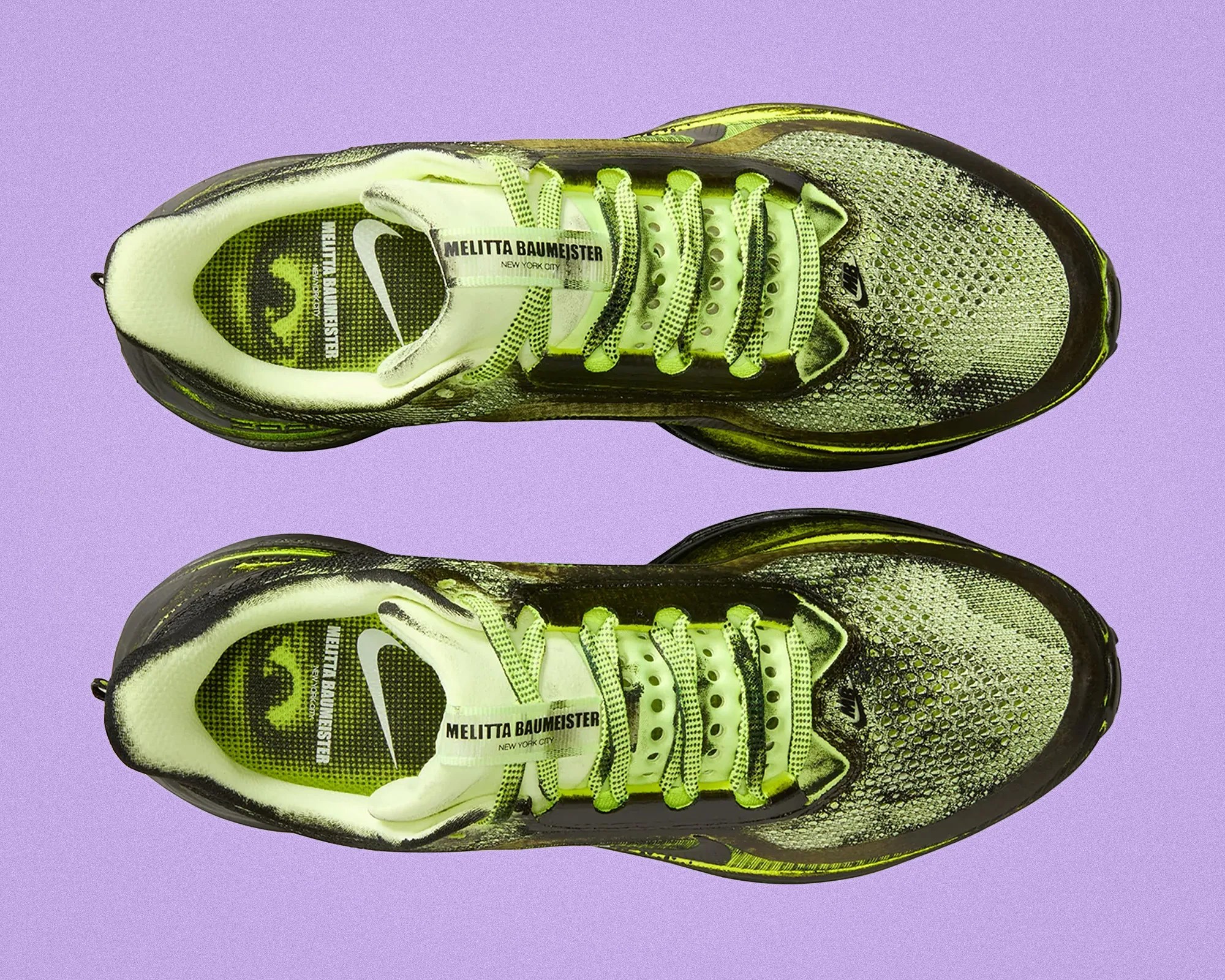 Pair of neon yellow and black Nike running shoes with "Melitta Baumeister New York City" text on the tongue, viewed from above.