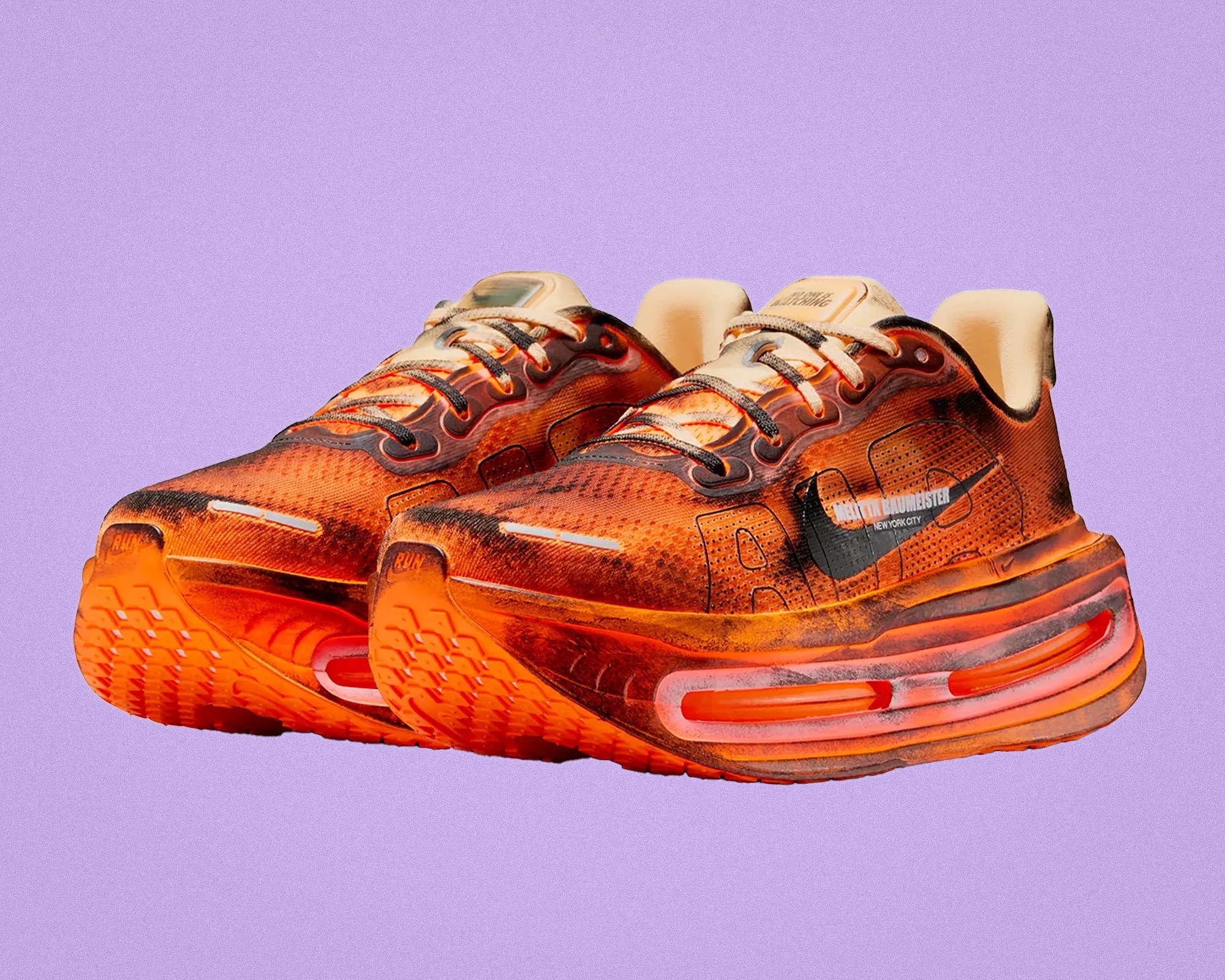 Pair of orange and black Nike running shoes with thick cushioned soles and black swoosh logos on a purple background.