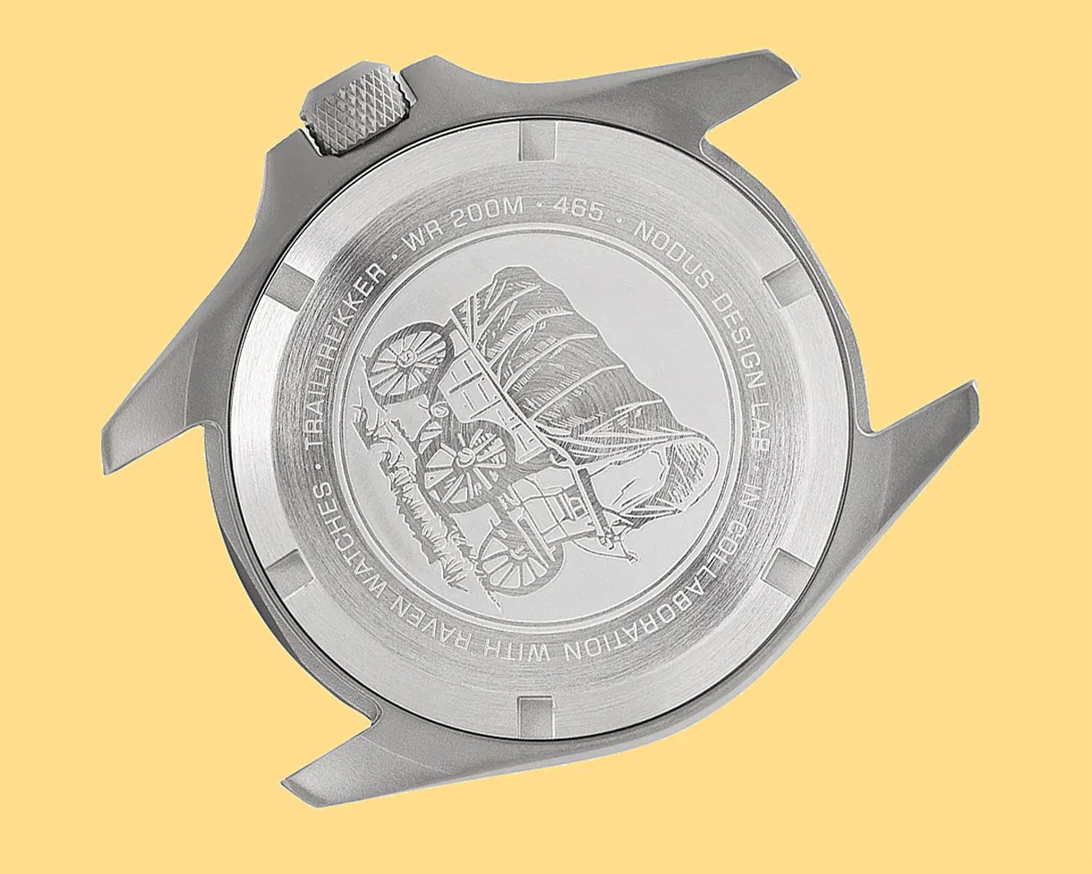 Brushed stainless steel watch case back engraved with a covered wagon and text around the edge.