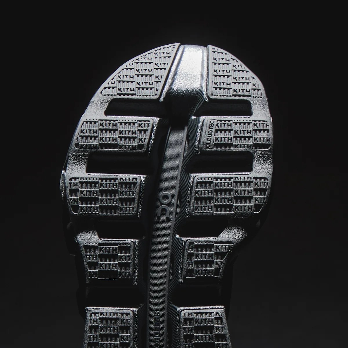 Black shoe sole with textured tread featuring repeated "KITH" branding and "CLOUDTEC" text on a dark background.