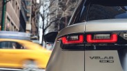 Rear view of a silver Range Rover Velar P380 HSE with illuminated taillights on a city street.