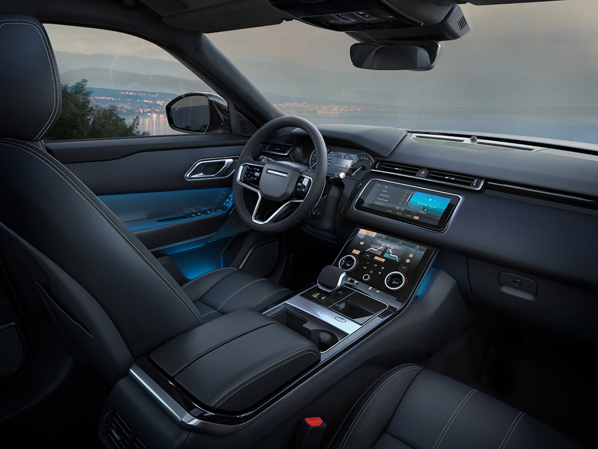 Luxury car interior with black leather seats, digital dashboard, and dual touchscreen center console.