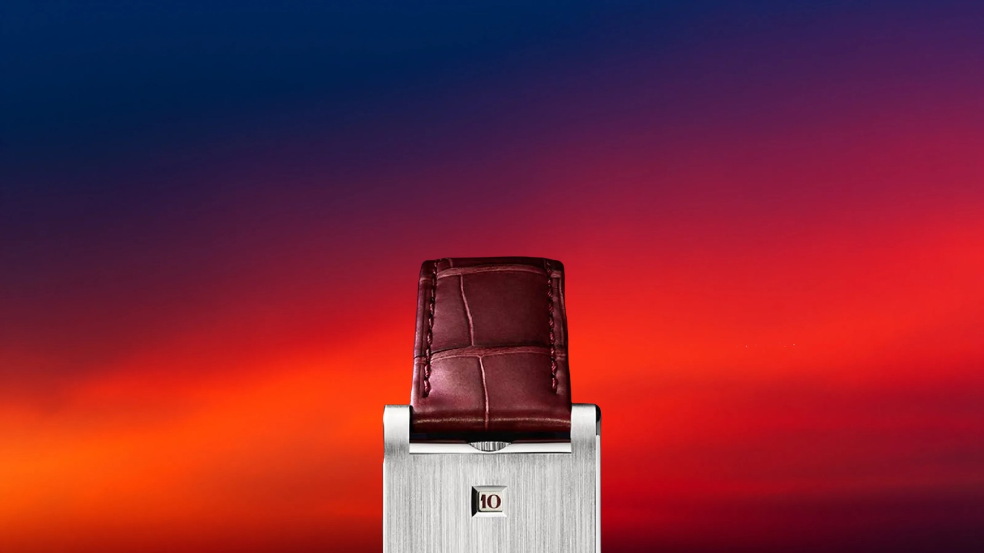 Silver rectangular watch with a burgundy leather strap against a gradient red and blue background.
