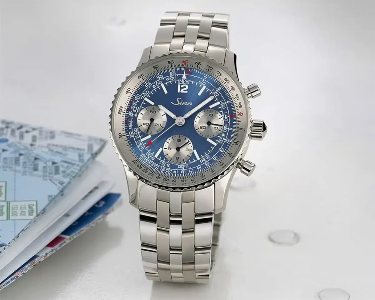 Silver stainless steel chronograph wristwatch with blue dial and three subdials on a white surface.