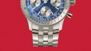 Close-up of a silver metal watch bracelet with polished and brushed links attached to a blue chronograph watch face.