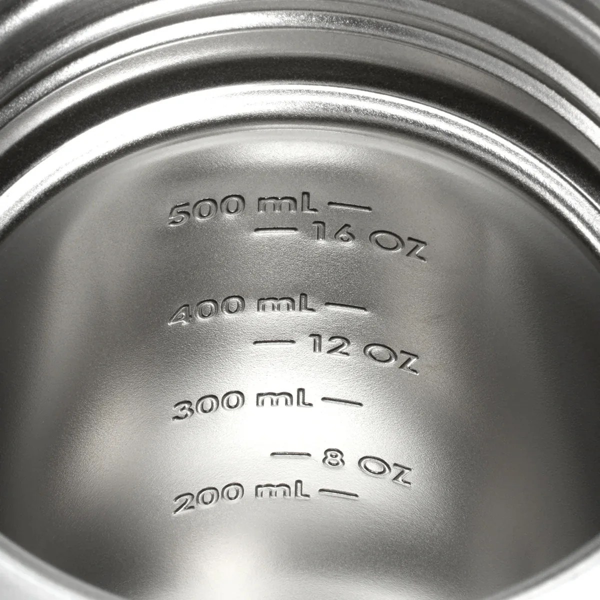 Interior of a metallic container with embossed volume measurements in milliliters and ounces.