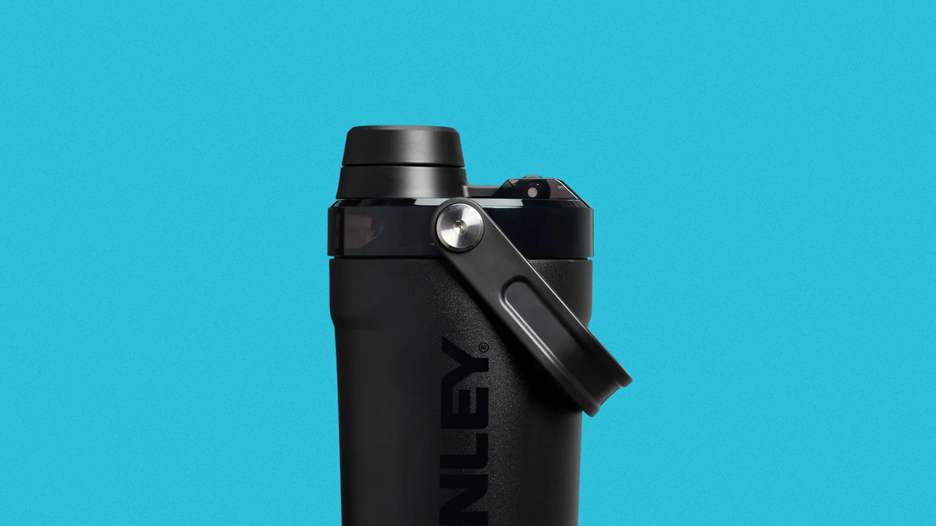Black Stanley insulated bottle with a black handle against a blue background.