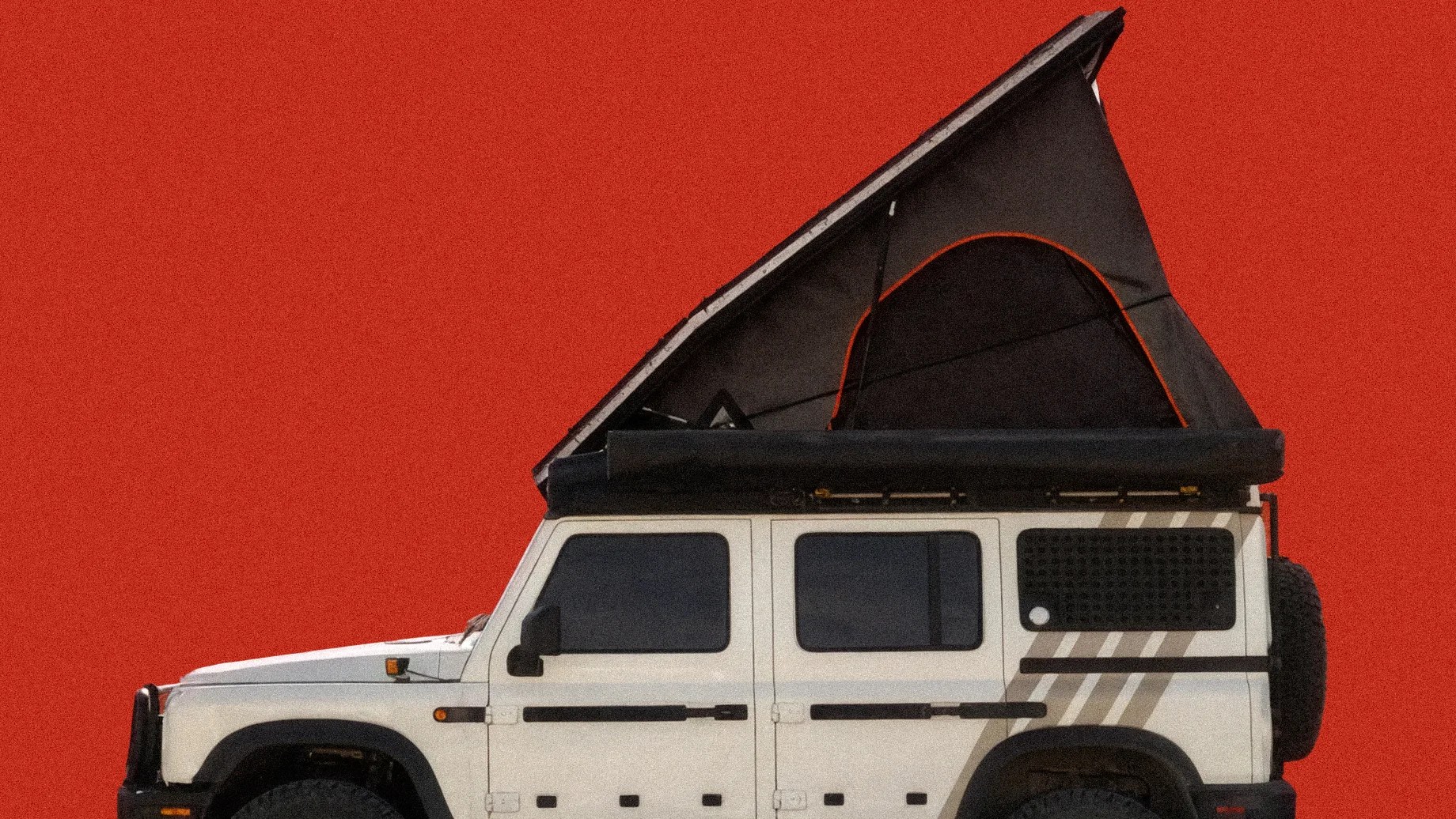 White off-road SUV with black pop-up roof tent against a red background.
