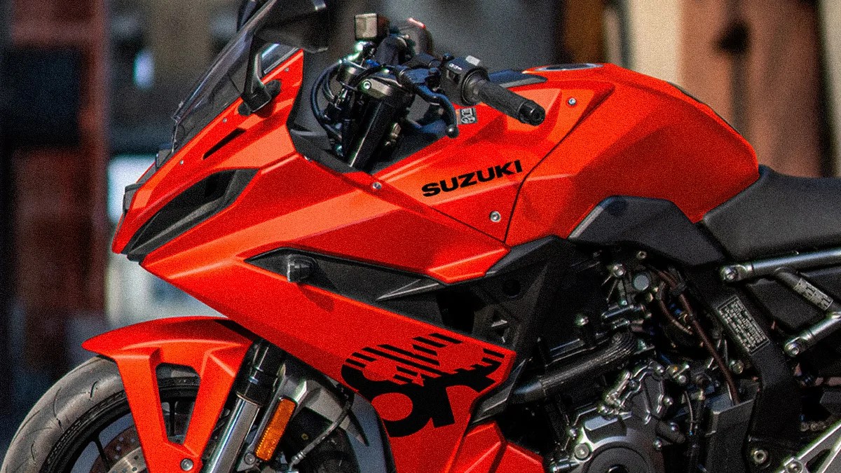 Close-up of a red Suzuki sport motorcycle showing the front wheel, handlebars, and engine area.