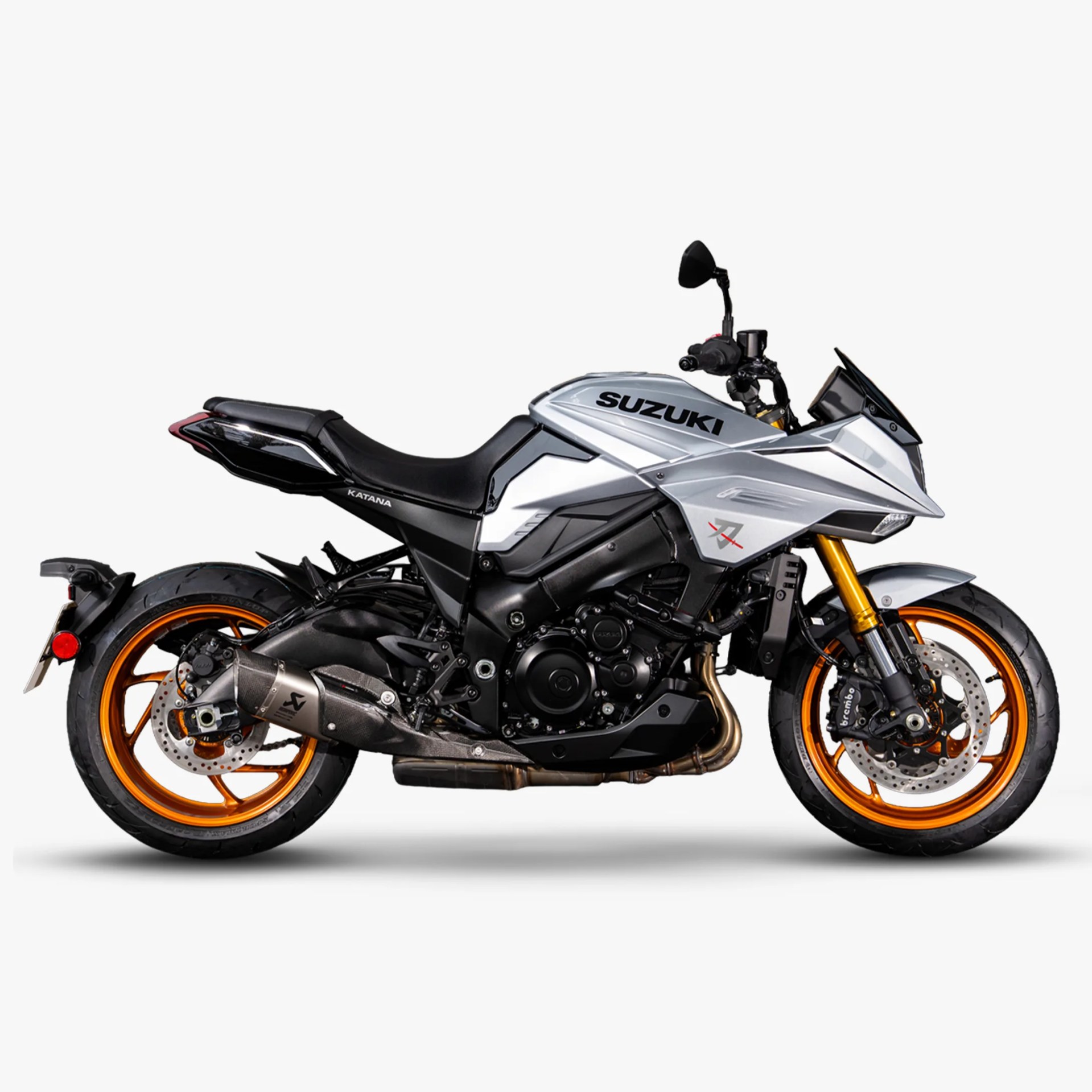 Silver Suzuki Katana motorcycle with black seat and orange rims on a white background.