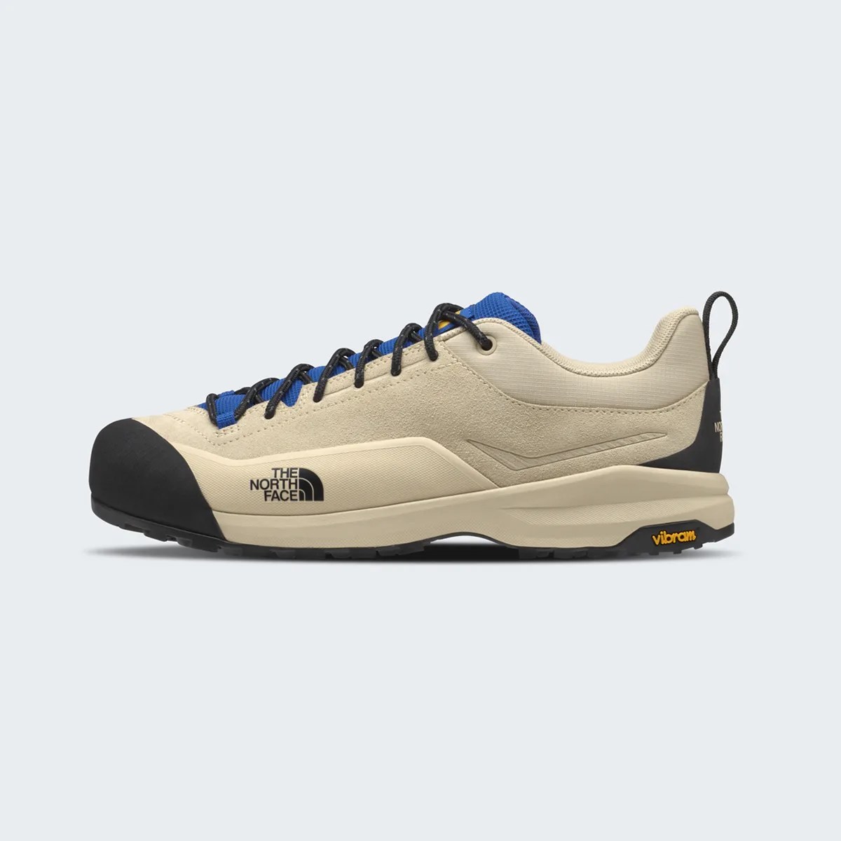 Beige and blue low-top hiking shoe with black toe cap and Vibram sole, featuring The North Face logo on the side.
