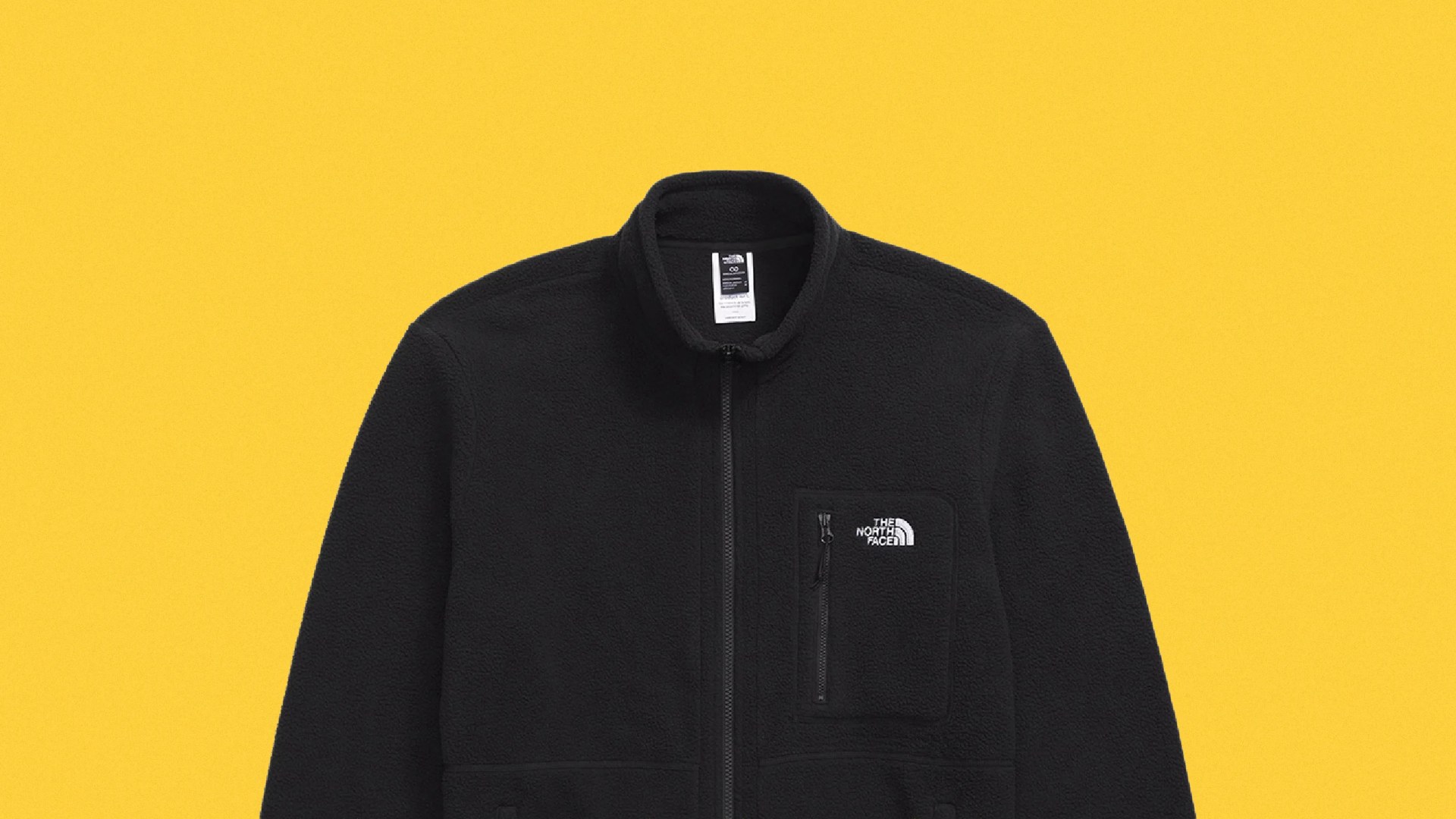 Black fleece jacket with full front zipper and zippered chest pocket on a yellow background.