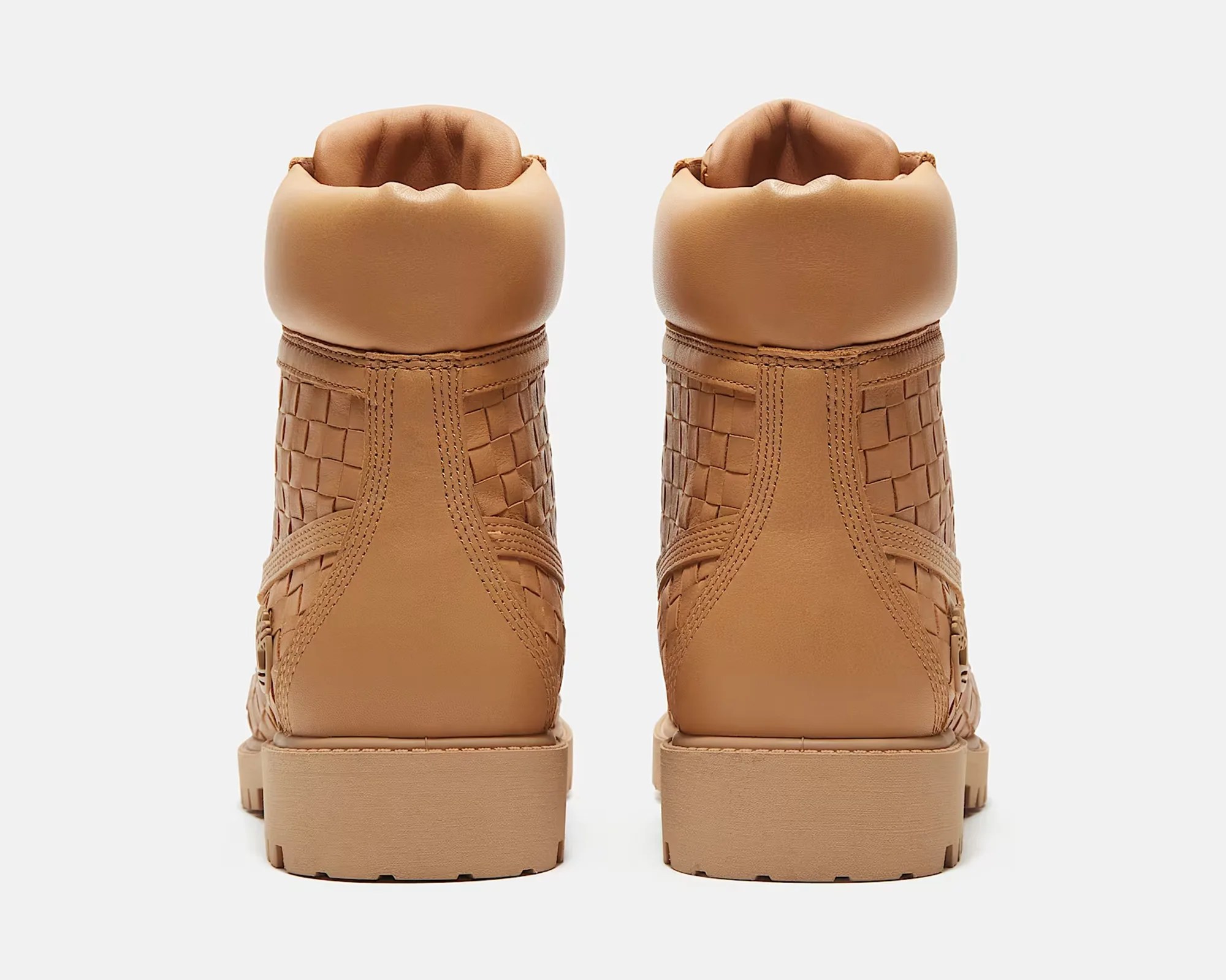 Pair of tan leather boots with woven side panels and padded collars, viewed from the back.
