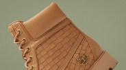 Tan leather boot with woven side panels and Timberland tree logo on the heel.