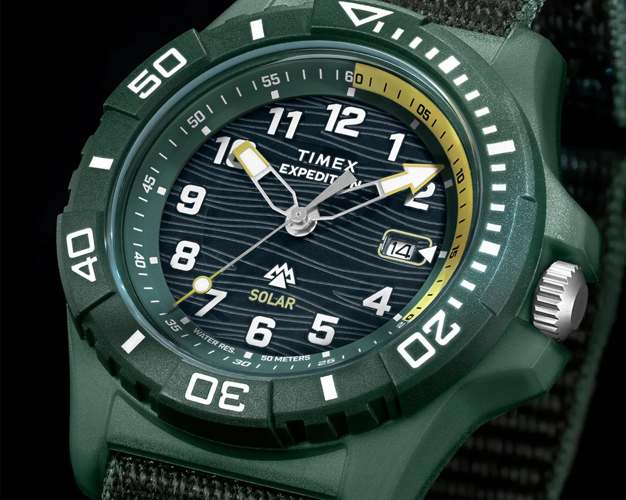 Green Timex Expedition solar watch with white numerals, yellow accents, and black fabric strap.