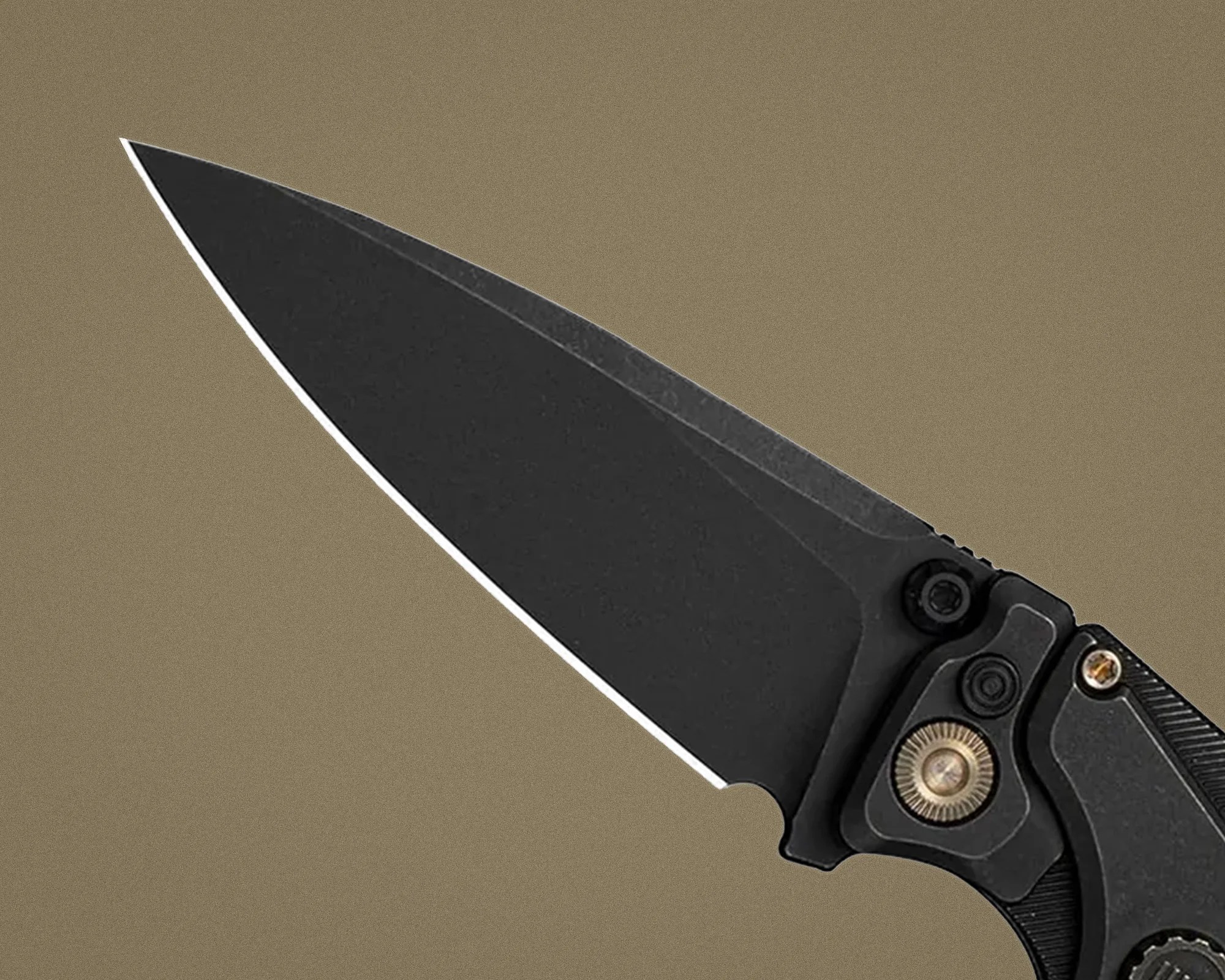 Black folding knife blade with a matte finish and a thumb stud on a tan background.