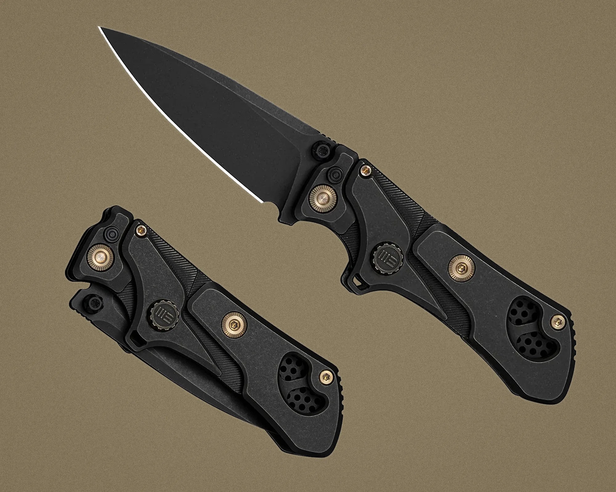 Two black folding knives with textured handles and bronze screws, one open and one closed, on a brown background.
