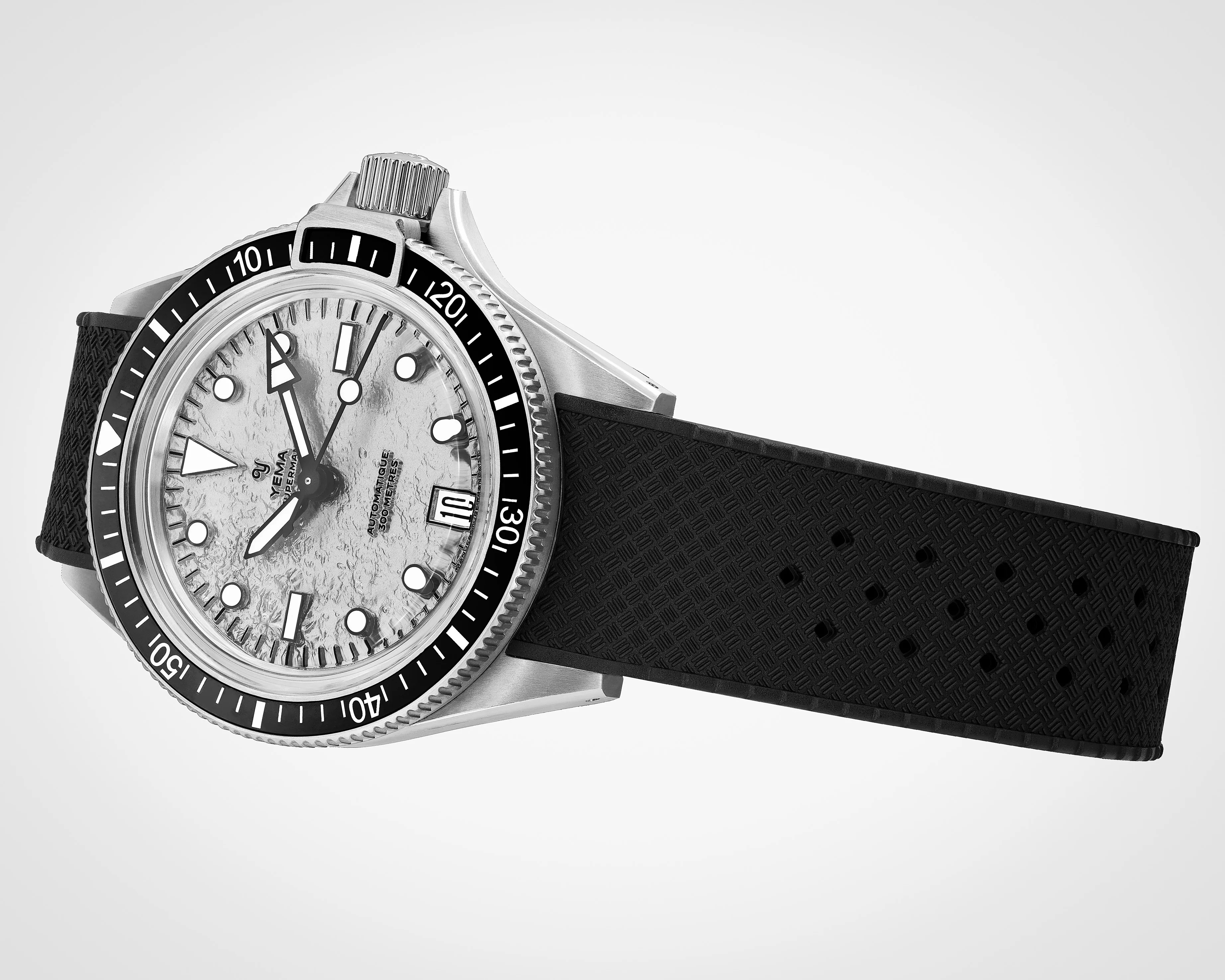 Silver Yema Superman dive watch with textured white dial, black bezel, and black patterned rubber strap.