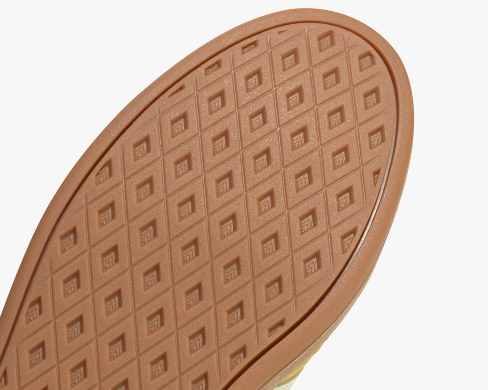 Close-up of a brown rubber shoe sole with a diamond-shaped tread pattern.