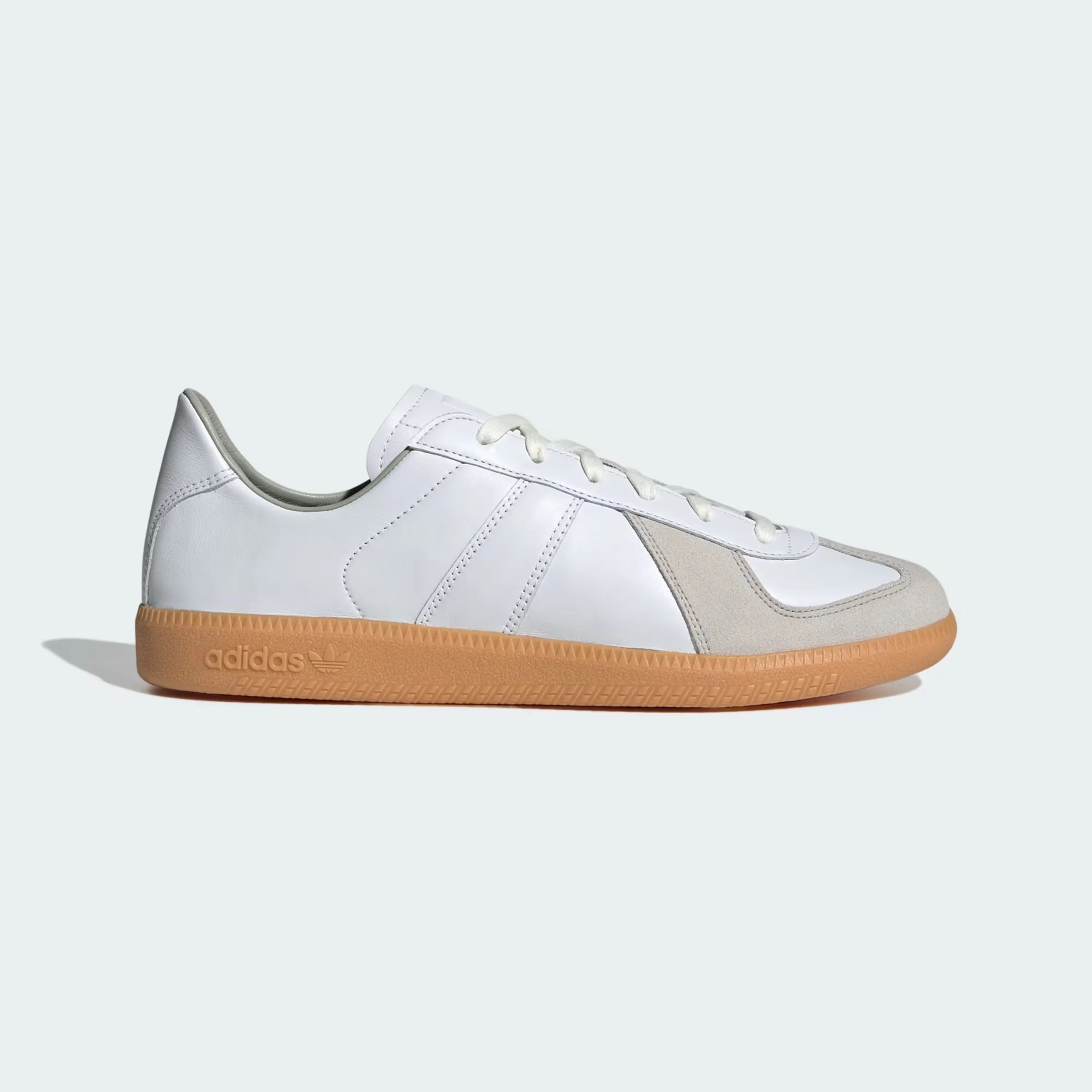 White leather Adidas sneaker with beige suede accents and gum rubber sole, side view.