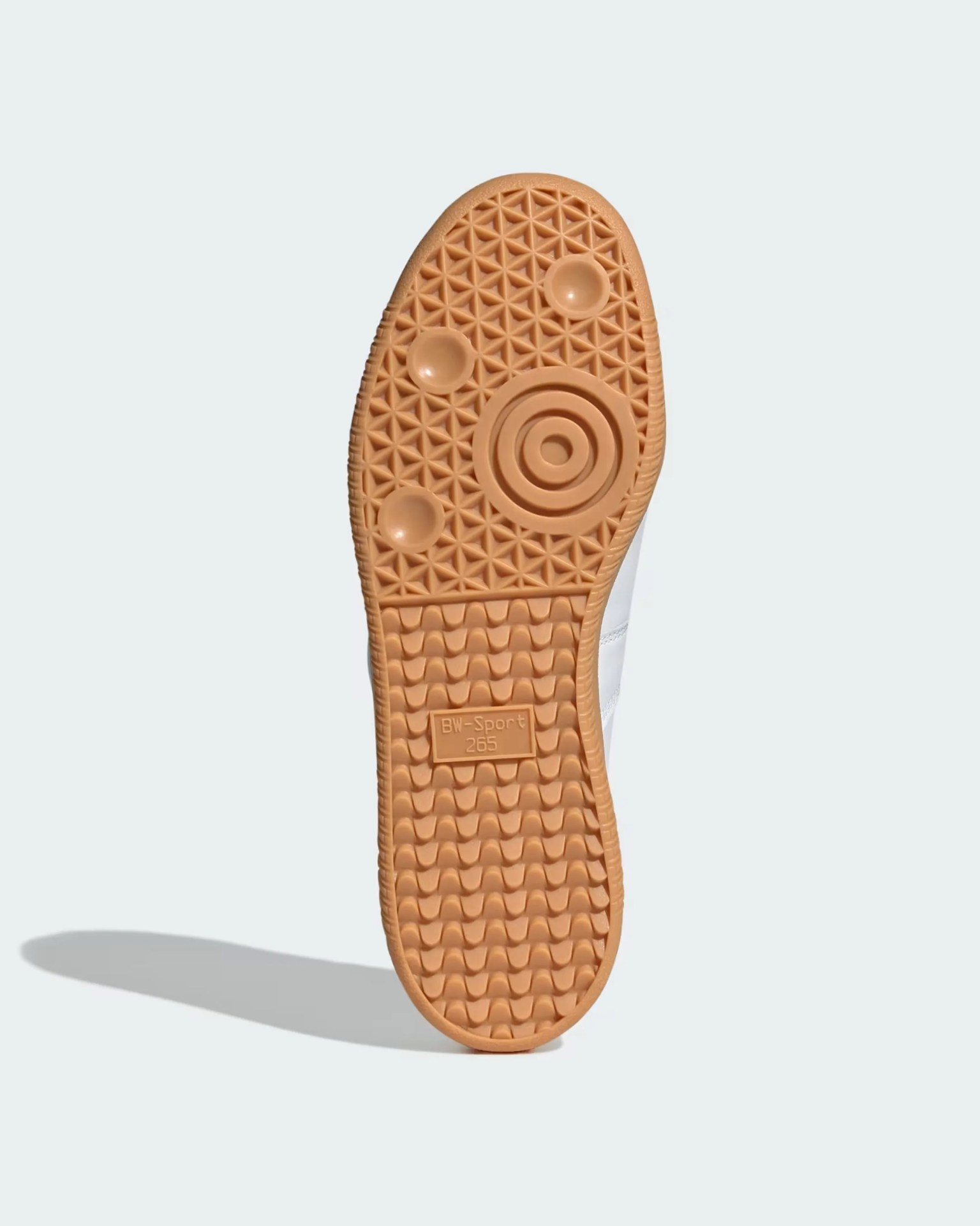 Light brown rubber sole of a white sneaker with circular and wave tread patterns and "BW-Sport 265" text.