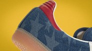 Close-up of a blue denim sneaker with star patterns, red leather heel tab, and translucent rubber sole against a yellow background.