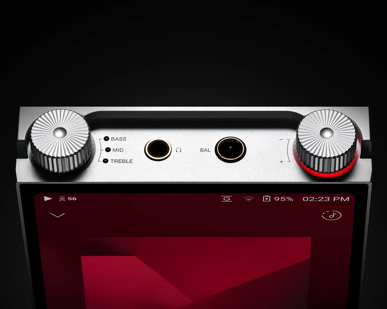 Top view of a silver audio device with two large textured control knobs, headphone and balance ports, and bass, mid, treble labels.