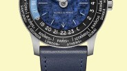 Close-up of a watch face with a blue textured dial, world city names on the bezel, and a blue leather strap.