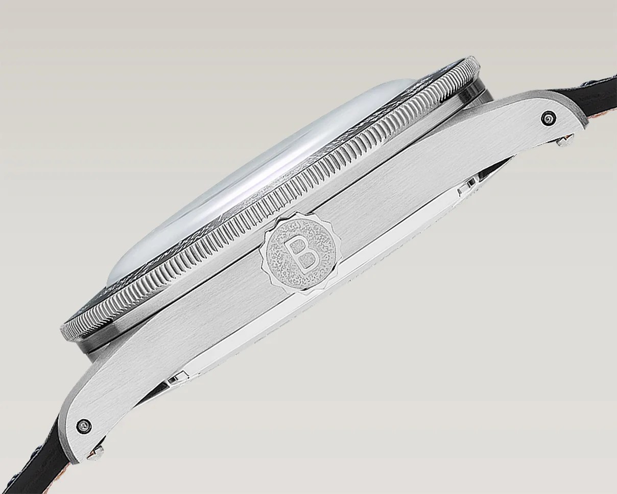 Side view of a silver wristwatch case with a textured crown marked with a "B" and a black leather strap.