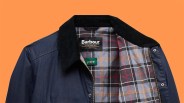 Navy Barbour jacket with black corduroy collar and gray plaid interior lining.