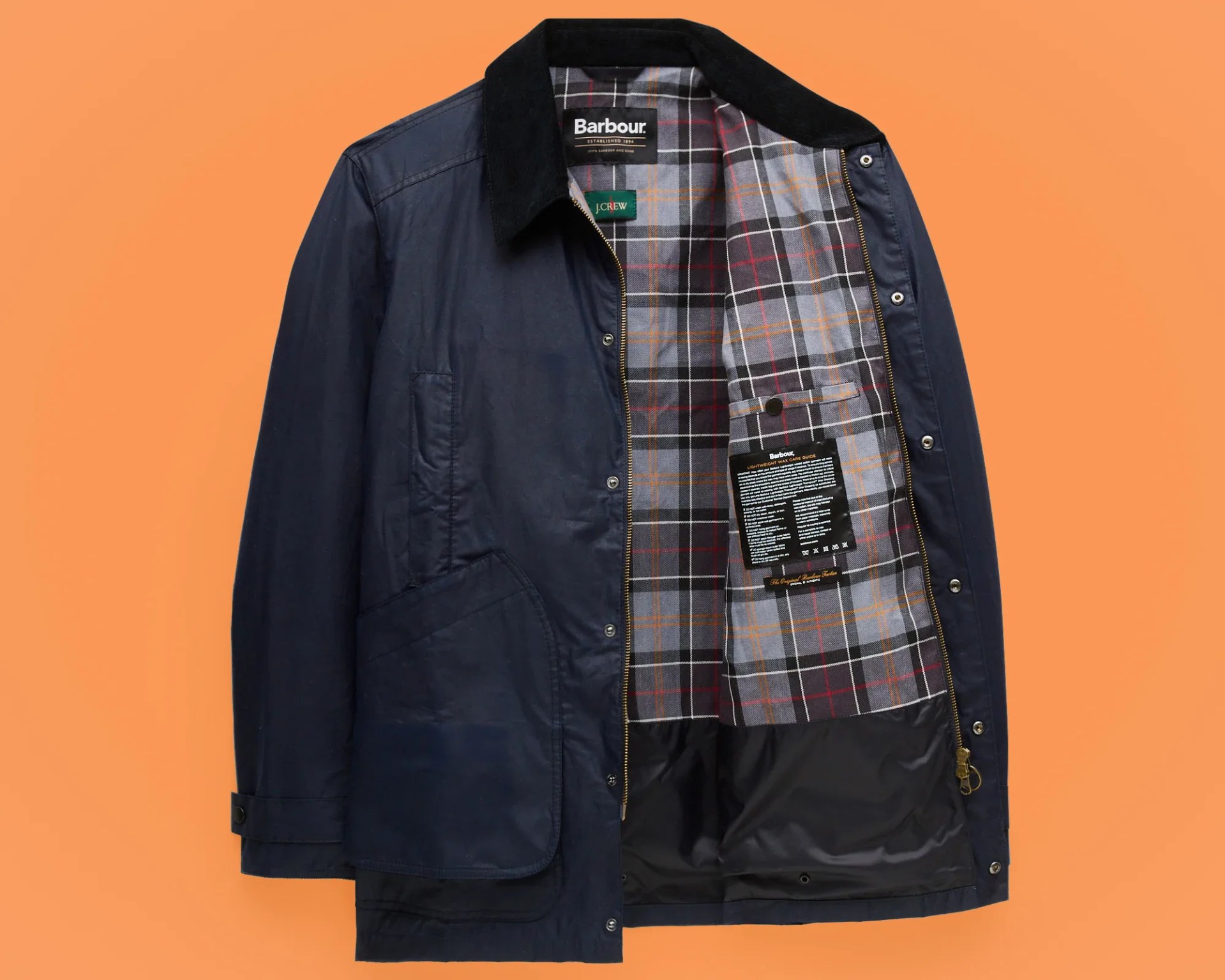 Navy Barbour jacket with black corduroy collar and plaid interior lining, unzipped and open.