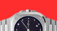 Close-up of a silver Bell & Ross watch with a starry black dial and diamond hour markers on a red background.