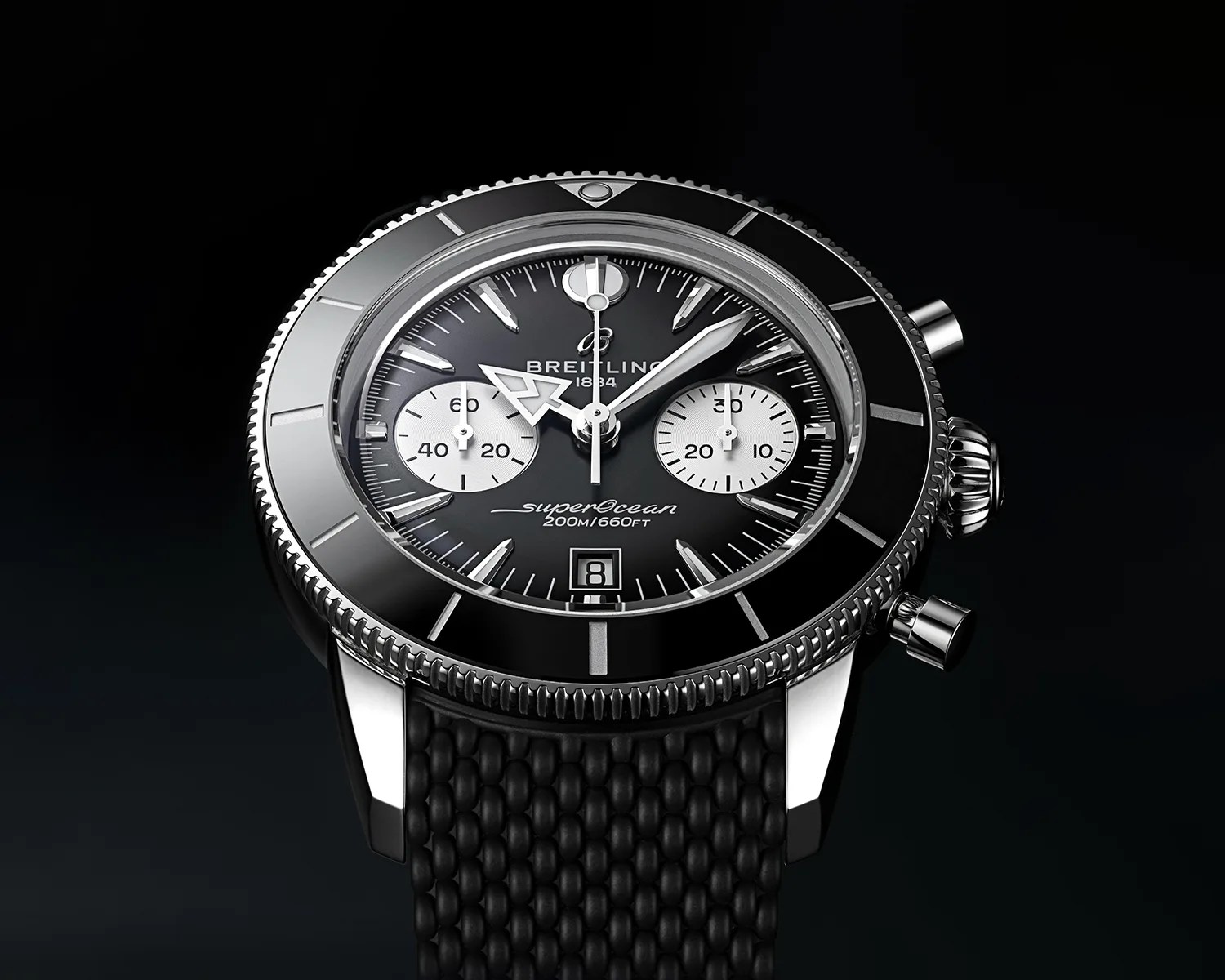 Black Breitling SuperOcean chronograph watch with silver bezel and black textured strap on black background.